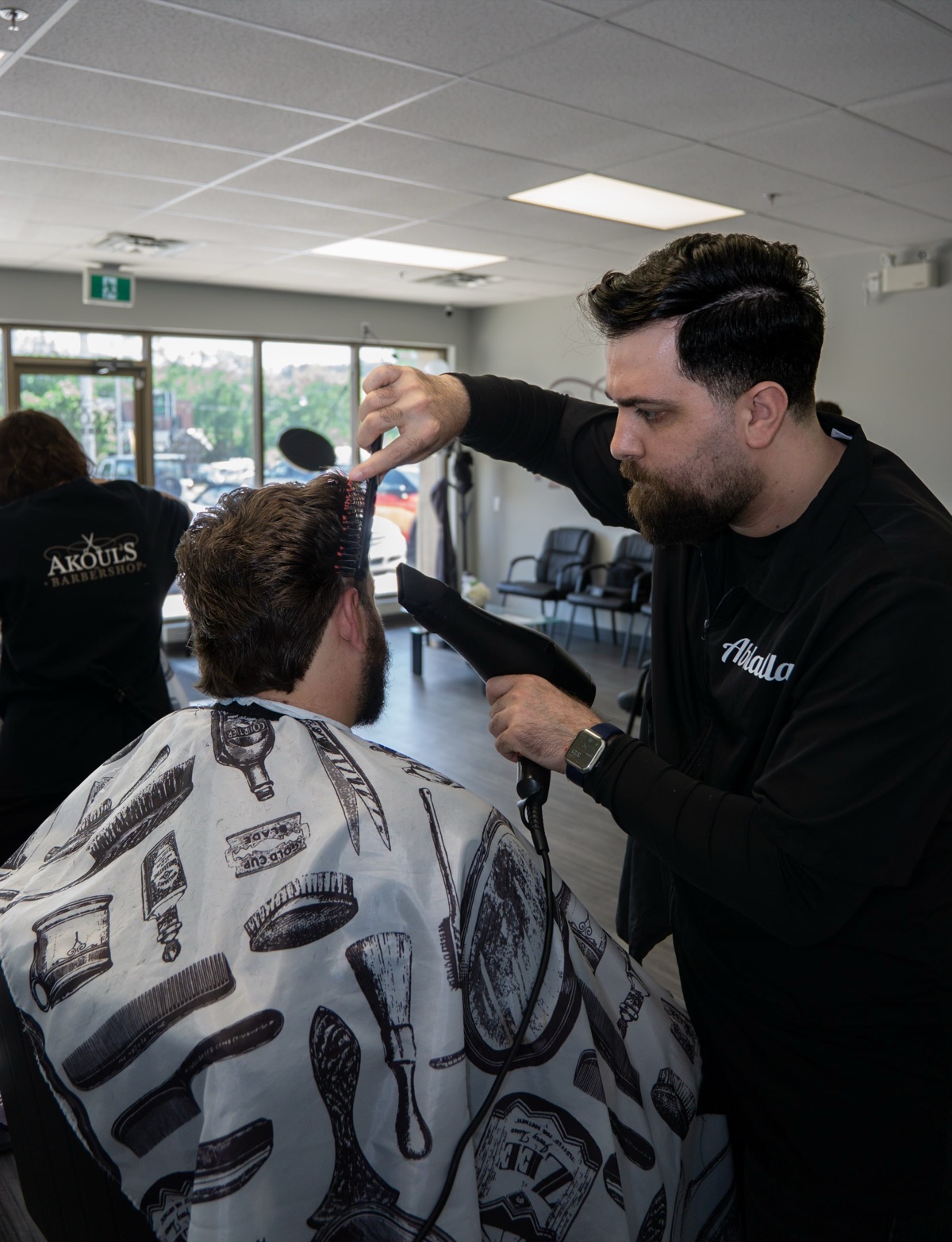 Barber styling a client's hair at Akoul's Barbershop — business photography in London Ontario